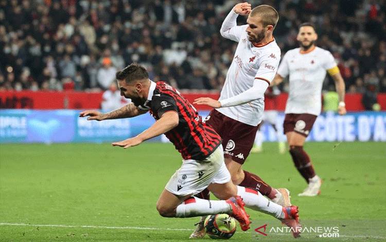 Penyerang OGC Nice Andy Delort (bawah) terjatuh saat berebut bola dengan bek Metz Thomas Delaine dalam laga lanjutan Liga Prancis di Stadion Allianz Riviera, Nice, Prancis, Sabtu (27/11/2021) waktu setempat. (ANTARA/AFP/Valery Hache)