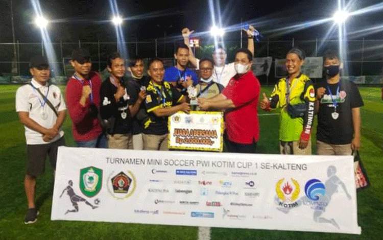 Ketua PWI Kalteng M Haris Sadikin meyerahkan hadiah kepada tim PWI Katingan
