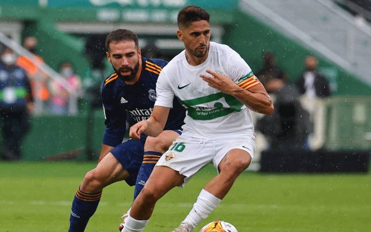 Pemain Elche CF Fidel Chaves (kanan) saat berduel dengan pemain Real Madrid Dani Carvajal dalam pertandingan Liga Spanyol di Martinez Valero Stadium, Elche, pada 30 Oktober 30 2021. (AFP/JOSE JORDAN)