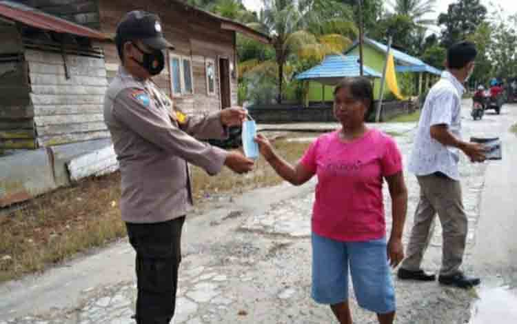 Anggota Polsek Timpah Bagikan Masker Sembari Ingatkan Disiplin Prokes