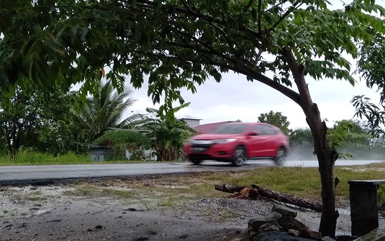 Sebuah mobil melaju di Jalan Soekarno-Hatta Kasongan yang diguyur hujan.