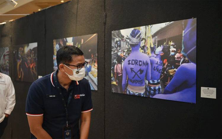 Menteri Sandiaga Uno mengunjungi pameran foto jurnalistik Rwa Bhineda di Seminyak Village, Bali, Jumat (17/12/2021). ANTARA/Ayu Khania Pranisitha. (Antara/Ayu Khania Pranisitha/2021)