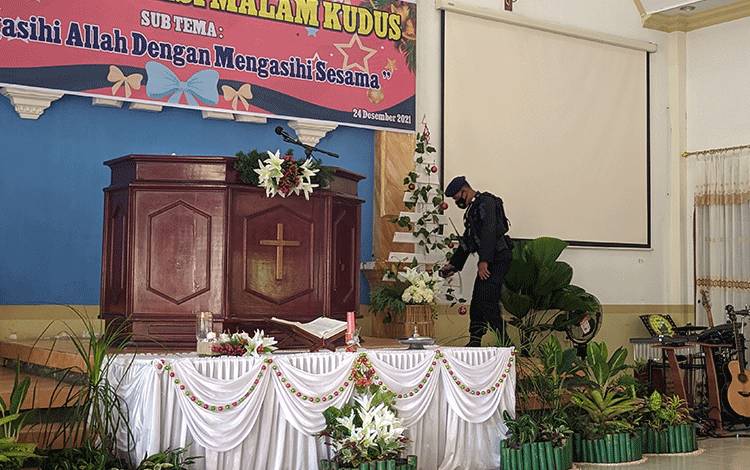 Anggota brimob saat melakukan sterilisasi di gereja.