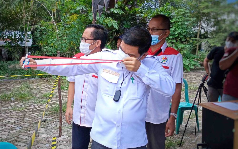 Bupati Barito Timur, Ampera AY Mebas mencoba olahraga tradisional mangatek atau katapel saat membuka perlombaan olahraga tradisional.