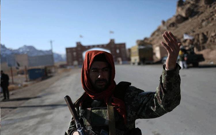 Seorang pejuang Taliban berdiri di sebuah pos pemeriksaan di dekat Bamiyan, Afghanistan, 24 Desember 2021. (REUTERS/ALI KHARA)