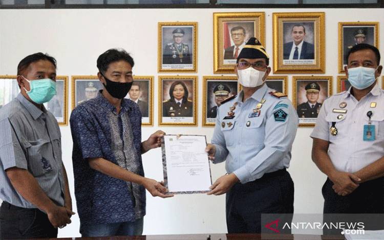Kepala Kantor Wilayah Kementerian Hukum dan Hak Asasi Manusia (Kakanwil Kemenkumham) Kalimantan Tengah Ilham Djaya (kedua kanan) menyerahkan surat keterangan terdaftar kepada Ketua Partai IBU Provinsi Kalimantan Tengah Martin Jakantan Pantar (kedua kiri) di Palangka Raya, Kamis (6/1/2022). ANTARA/HO-Kanwil Kemenkumham Kalteng
