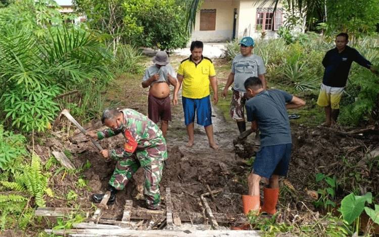 Serka Syarifudin bahu membahu bersama warga Jalan Karanggan memperbaiki jembatan, Minggu, 9 Januari 2022.
