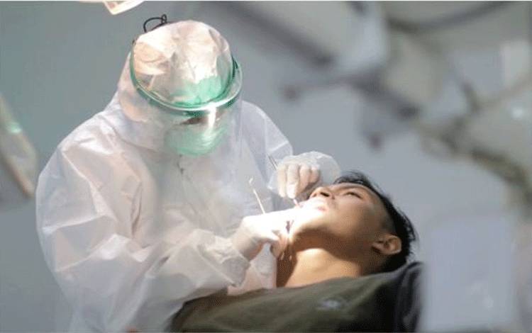 Dokter gigi memeriksa gigi pasien sambil mengenakan APD lengkap (ANTARA/HO - Humas RSUD dr. Iskak Tulungagung)
