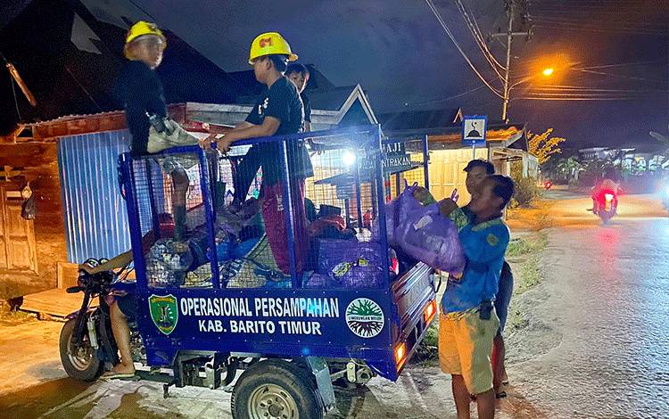 Relawan PMK Nurul Hayat RT 19 Kelurahan Ampah Kota saat mengangkut sampah dari rumah-rumah warga, Sabtu, 15 Januari 2021.