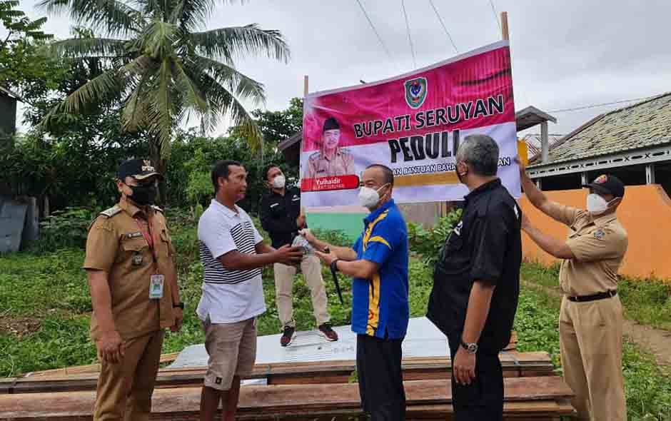 Bupati Seruyan Yulhaidir saat menyerahkan bantuan bahan bangunan kepada perwakilan warga setempat