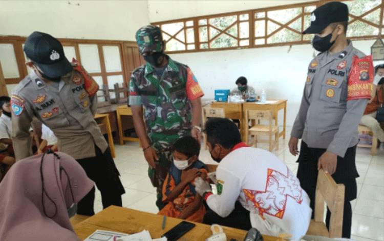 Tim medis kesehatan covid 19 dan lainnya saat melakukan vaksinasi kepada salah satu murid SDN 1 Gadabung, Kecamatan Pandih Batu, Kabupaten Pulang Pisau, Senin, 24 Januari 2022.