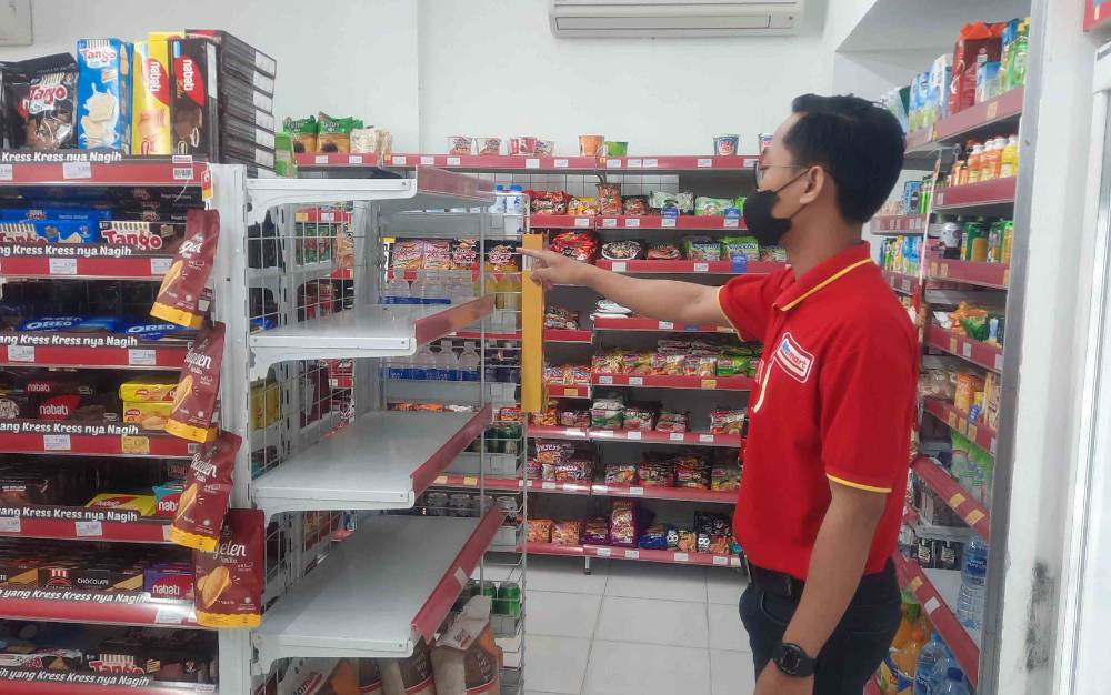 Karyawan Alfamart di Pangkalan Bun saat menunjukkan rak minyak goreng yang kosong