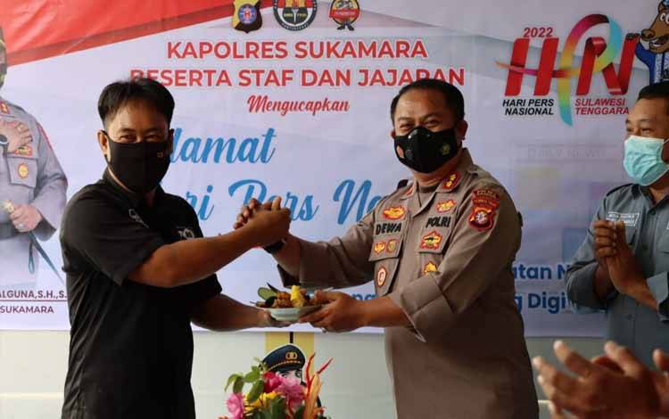 Kapolres Sukamara AKBP Dewa Made Palguna menyerahkan potongan tumpeng kepada Ketua PWI Sukamara, Ferianto