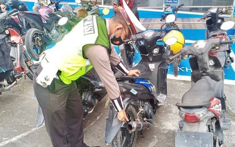 Personel Satlantas Polres Kobar menunjukan motor menggunakan knalpot brong.