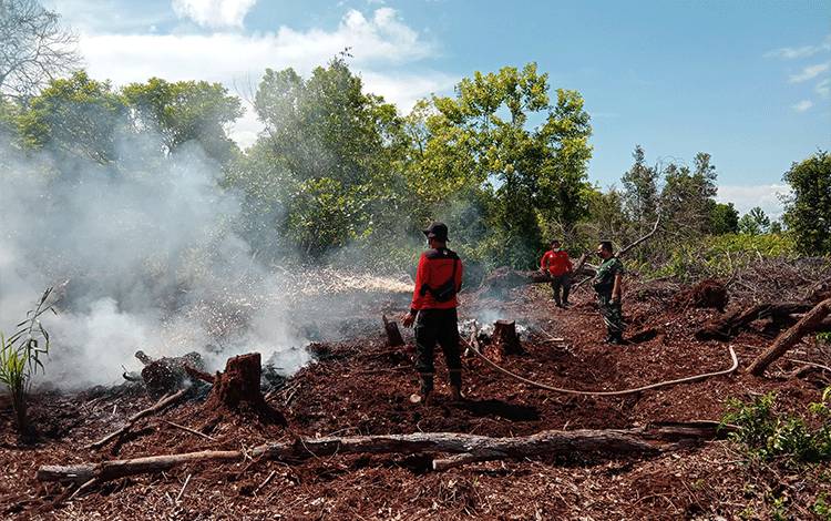 Personel tim Manggala Agni yang dibantu TNI saat memadamkan api di lokasi kejadian, di Desa Tanjung Taruna, Kecamatan Jabiren Raya, Kabupaten Pulang Pisau, Senin, 14 Februari 2022.