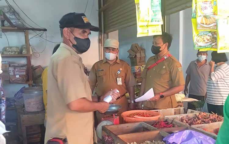 Dinas Perdagangan, Koperasi dan UKM Kabupaten Barito Timur bersama TNI dan Satpol PP saat melakukan sosialisasi HET minyak goreng di Pasar Tamiang Layang