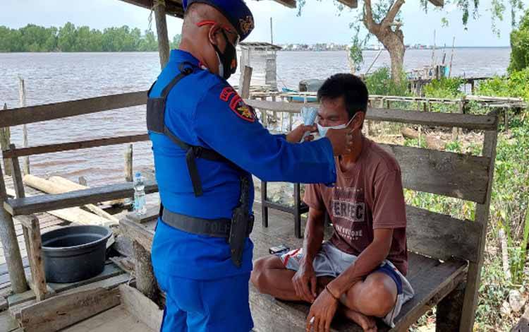Anggota Satpolairud Polres Katingan memberikan masker kepada warga Pegatan
