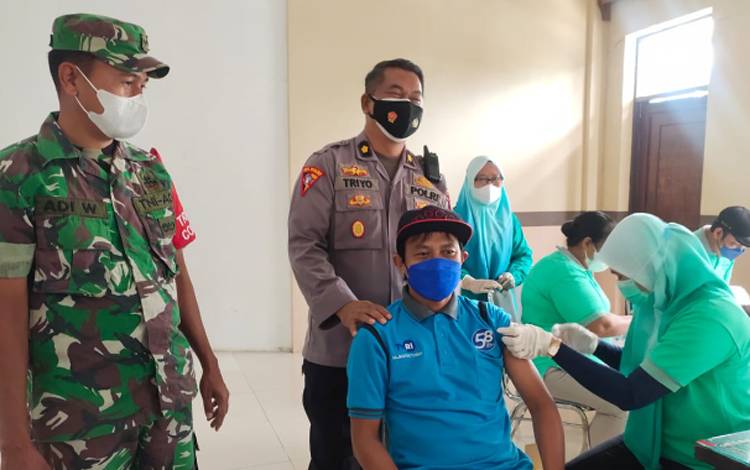 Anggota TNI dan Polri turut melakukan pengamanan kepada warga yang ikut vaksinasi Covid-19 di Gedung Selawah, Jumat, 18 Februari 2022.