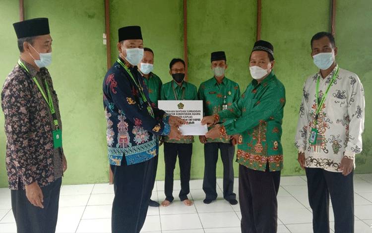 Kepala Kemenag Kapuas, Hamidhan saat menyerahkan bantuan UPZ Kemenag kepada MTsN 2 Kapuas.