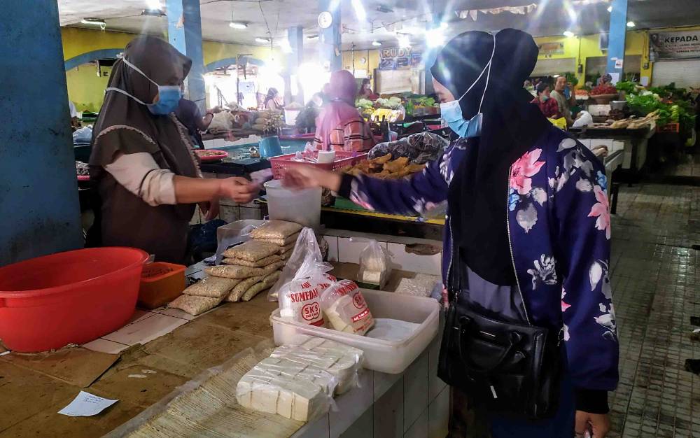 Pedagang tahu tempe di Pasar Ikan Mentaya melayani pembeli.