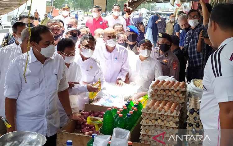Menteri Perdagangan Muhammad Luthfi (depan) berserta Wali Kota Banda Aceh Aminullah Usman (tiga dari menteri) beserta rombongan saat mengecek harga minyak goreng di pasar Al Mahirah Banda Aceh, di Banda Aceh, Sabtu (26/2/2022)