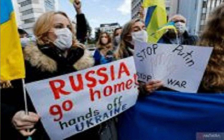 Warga Ukraina yang tinggal di Jepang memegang poster dan bendera selama demonstrasi mengecam Rusia atas tindakannya di Ukraina, dekat kedutaan Rusia di Tokyo, Jepang, Rabu (23/2/2022). (ANTARA FOTO/REUTERS/Issei Kato/wsj)