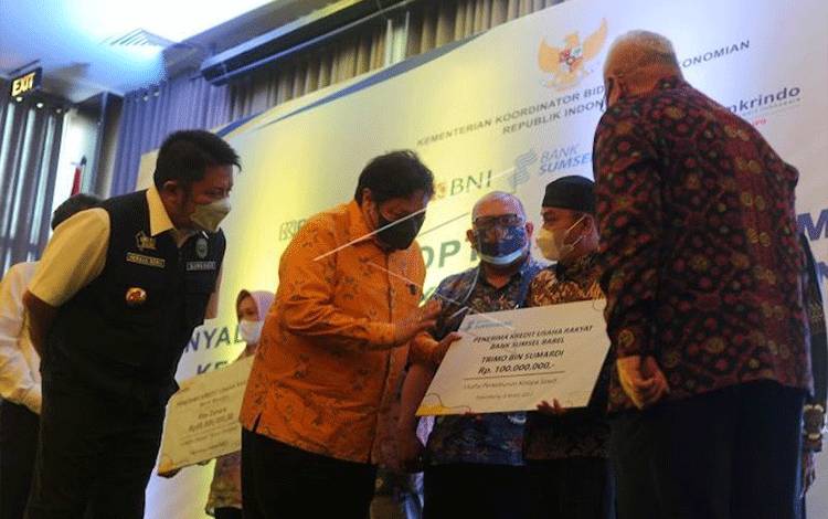 Menko Perekonomian Airlangga Hartarto (kedua kiri) dan Gubernur Sumatera Selatan Herman Deru (kiri) berbincang dengan salah satu debitur penerima saat menyerahkan penyaluran Kredit Usaha Rakyat (KUR) di Palembang, Sumatera Selatan, Jumat (4/3/2022). Pada kesempatan tersebut disalurkan KUR sebesar Rp4,23 miliar kepada 32 debitur di Sumatera Selatan. (ANTARA FOTO/Feny Selly)