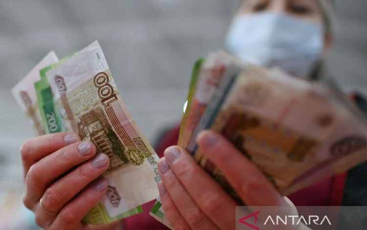 Seorang vendor menghitung uang kertas rubel Rusia di sebuah pasar di Omsk, Rusia, Jumat (18/2/2022)