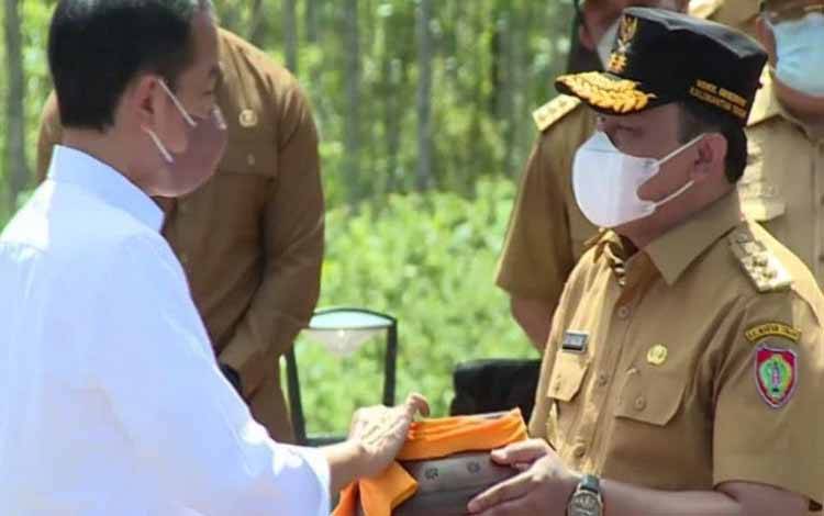Presiden Joko Widodo dan menerima tanah dan air dari daerah yang diserahkan Wagub Kalteng Edy Pratowo di di titik nol Ibu Kota Negara (IKN) Nusantara, Kabupaten Penajam Paser Utara, Kalimantan Timur, Senin (14/3/2022)