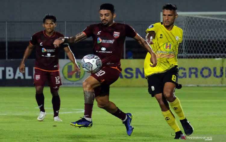 Pesepak bola Borneo FC Jonathan Bustos (tengah) berebut bola dengan pesepak bola Barito Putera Raphael Maitimo (kanan) pada pertandingan Liga 1 di Stadion Kompyang Sujana, Denpasar, Bali, Jumat (14/1/2022)