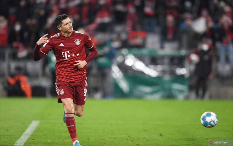 Striker Bayern Munich Robert Lewandowski melakukan selebrasi setelah mencetak gol ketiga Bayern saat menghadapi Union Berlin pada pertandingan Bundesliga di Allianz Arena, Munich, Jerman, Sabtu (19/3/2022) (REUTERS/ANDREAS GEBERT)