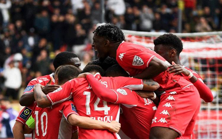 Pemain Monaco Wissam Ben Yedder dikerubuti rekan-rekan satu timnya setelah memasukkan gol dari tendangan penalti yang menuntaskan kemenangan 3-0 Monaco atas Paris Saint Germain (PSG) di Louis II Stadium (Stade Louis II) di Monako, 20 Maret 2022. (AFP/CLEMENT MAHOUDEAU)