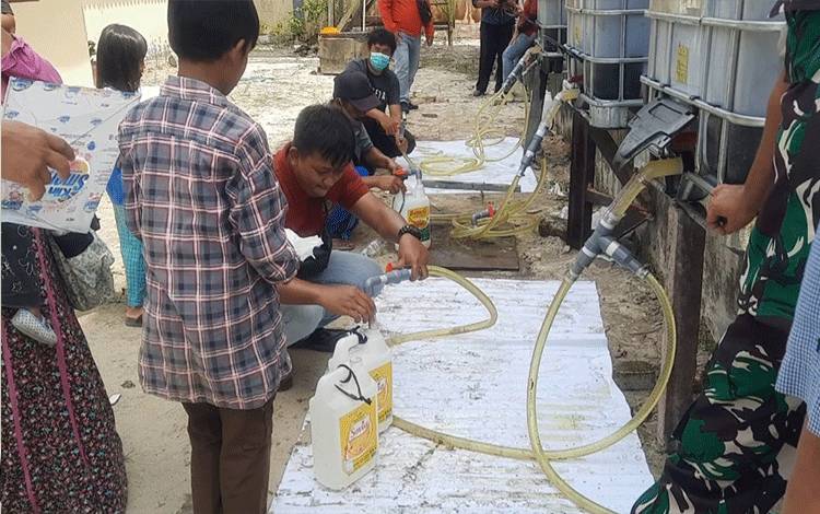 Petugas dari PT.CBU saat mendistribusikan minyak curah untuk warga.