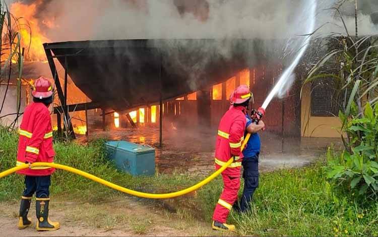 Personel Damkar Kobar saat memadamkan api yang membakar rumah warga