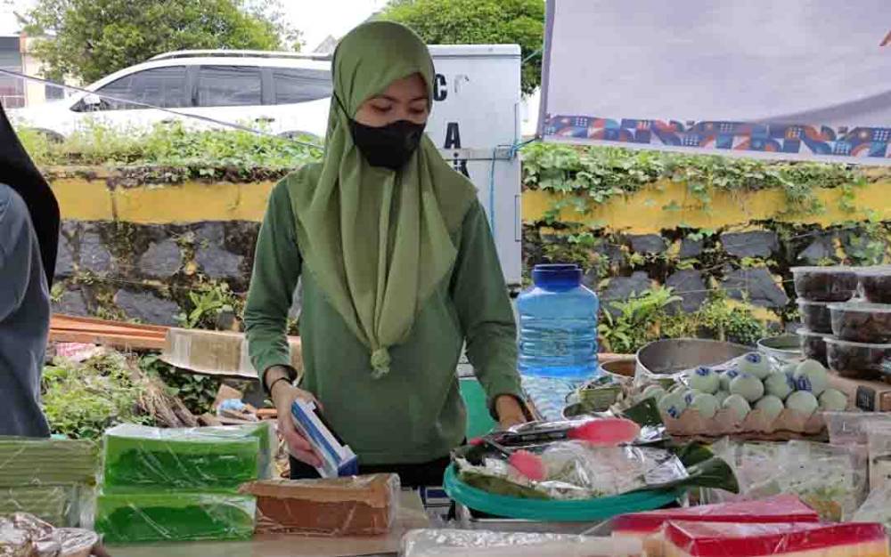 Salah seorang pedagang makanan, Rahma saat melayani pelanggan di Pasar Wadai Ramadan, Pasar Kahayan Palangka Raya, Senin 4 April 2022.