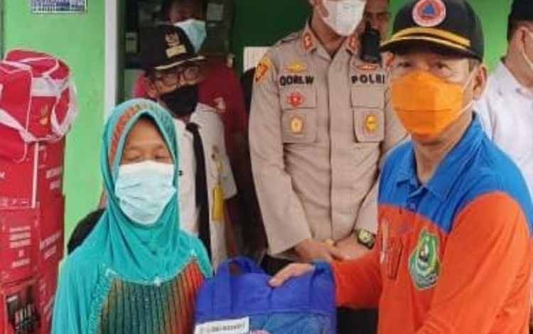 Kepala Pelaksana BPBD Kapuas, Panahatan Sinaga saat menyalurkan bantuan kepada warga terdampak kebakaran