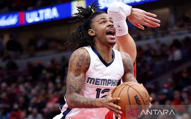 Bintang Memphis Grizzlies Ja Morant berusaha melewati pemain Chicago Bulls Nikola Vucevic (tak tampak muka) dalam lanjutan NBA di United Center, Illinois, Amerika Serikat, Sabtu (26/2/2022)