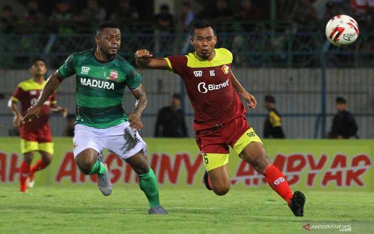 Pesepak bola Madura United David Laly (kiri) dihadang pesepak bola Persik Munhar (kanan) saat pertandingan babak penyisihan Grup A Piala Gubernur Jawa Timur 2020 di Stadion Gelora Bangkalan (SGB), Bangkalan, Jawa Timur, Rabu (12/2/2020). Madura United mengalahkan Persik dengan skor akhir 1-0