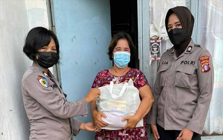 Personel Polwan Polres Kapuas saat membagikan paket sembako kepada warga di Kecamatan Selat