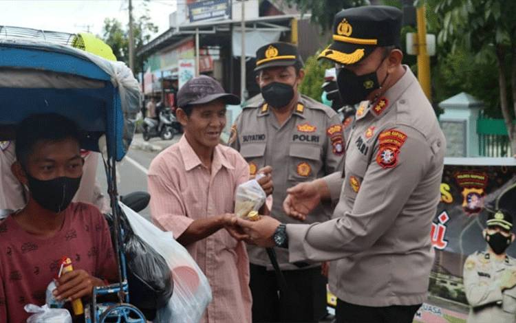 Kapolres Kapuas AKBP Qori Wicaksono membagikan takjil kepada masyarakat Kota Kuala Kapuas.