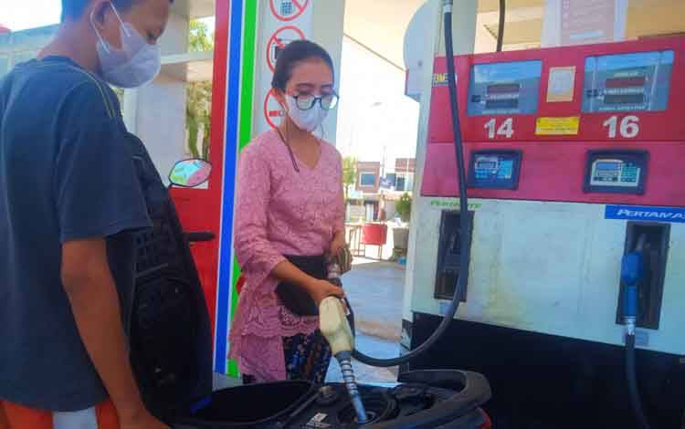 Salah satu karyawati SPBU sedang mengisi BBM ke kendaraan