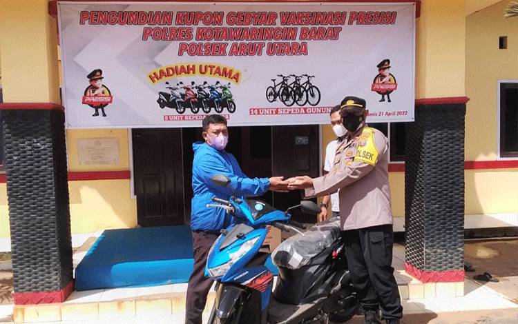 Kapolsek Aruta IPDA Agung Sugiharto serahkan sepeda motor hasil undian vaksin berhadiah.