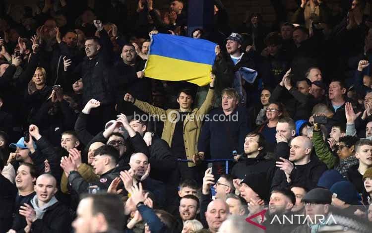 Penonton mengibarkan bendera Ukraina sebelum pertandingan laga Liga Inggris antara Manchester City melawan Everton di Goodison Park, Liverpool, Inggris (26/2/2022)