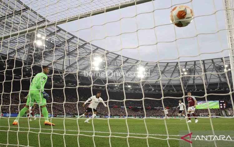 main Eintracht Frankfurt Ansgar Knauff mencetak gol ke gawang West Ham United yang dijaga Alphonse Areola (kiri) pada pertandingan babak Semi Final leg pertama Liga Eropa di Stadion London, London, Inggris, Kamis (28/4/2022). West Ham United tumbang 1-2 saat menjamu Eintracht Frankfurt di laga tersebut.