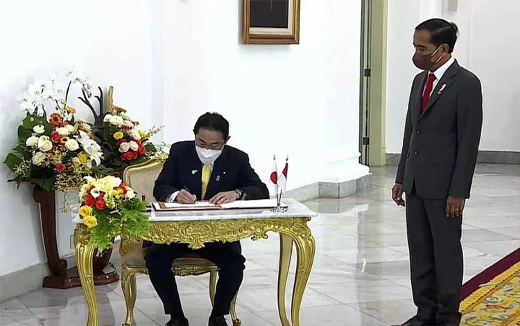 Tangkapan layar - Presiden Joko Widodo (kanan) menyaksikan saat Perdana Menteri Jepang Kishida Fumio mengisi buku tamu kenegaraan di Istana Kepresidenan Jakarta, Jumat (29/4/2022). (ANTARA/Gilang Galiartha)