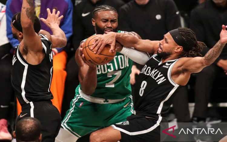 Pebasket Boston Celtics Jaylen Brown (7) dan pebasket Brooklyn Nets Patty Mills (8) berusaha mendapatkan bola di babak kedua pertandingan basket NBA di Barclays Center, Brooklyn, New York, Amerika Serikat, Sabtu (23/4/2022)