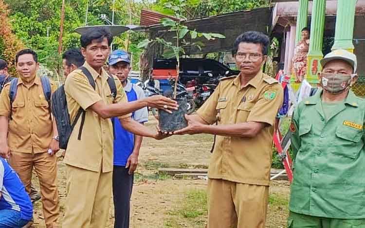 Kepala Desa Malintut, Yunus AG saat menyerahkan secara simbolis bibit lengkeng kepada warga.