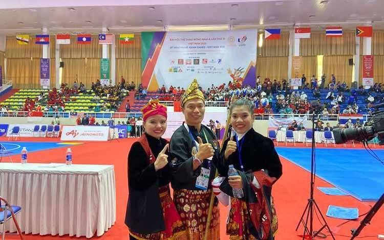 Riska (kanan) dan Ririn berfoto bersama pelatih setelah dinyatakan wasit menjadi peraih emas SEA Games nomor seni ganda putri di Bac Tu Liem Stadium, Hanoi, Rabu (11/5/22)