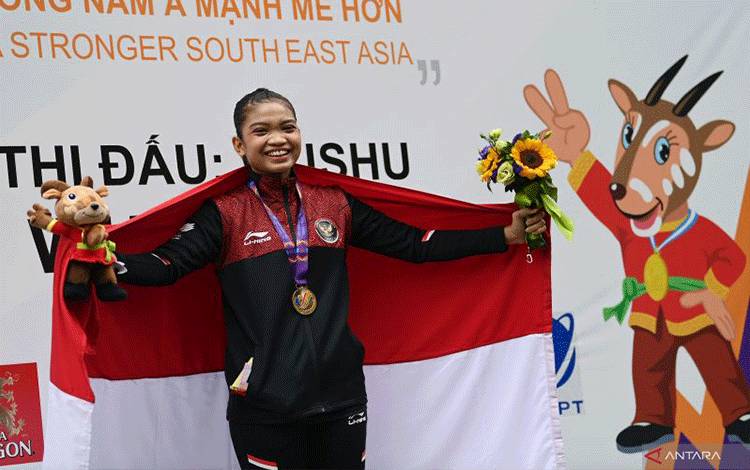 Pewushu Indonesia Alisya Mellynar membawa bendera Merah Putih usai pengalungan medali nomor taolu taiji quan putri wushu SEA Games 2021 Vietnam di Cau Giay Gymnasium, Hanoi, Vietnam, Sabtu (14/5/2022). Alisya meraih medali emas dalam nomor pertandingan tersebut dengan perolehan poin 9,71. ANTARA FOTO/Aditya Pradana Putra/rwa. (ANTARA FOTO/ADITYA PRADANA PUTRA)