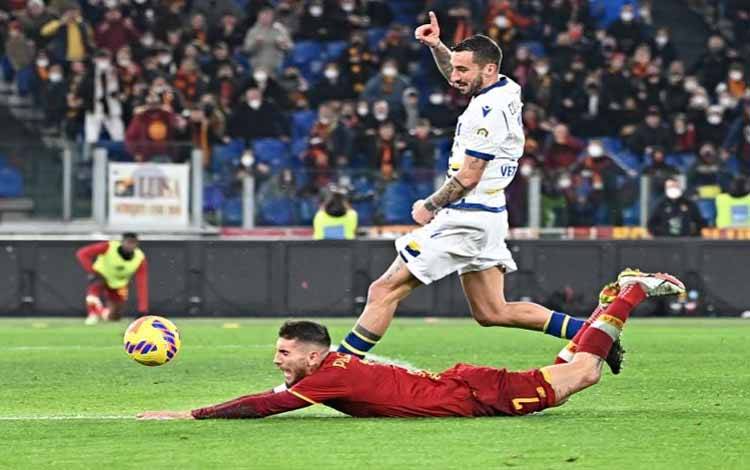 Gelandang serang AS Roma Lorenzo Pellegrini (bawah) terjatuh setelah berebut bola dengan bek Verona Federico Ceccherini dalam lanjutan Liga Italia di Stadion Olimpico, Roma, Italia, Sabtu (19/2/2022) waktu setempat